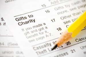 White tax deduction sheet claiming gifts to charity with a yellow pencil on tax form