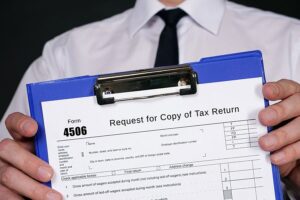 An accountant holding up a blue clipboard with a 4506-tax form that is a request for a copy of a previously filed tax return in Springfield, IL.