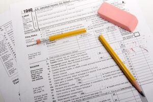 A stack of tax returns with a broken pencil and pink eraser sitting on an accountant’s desk in Springfield, IL.