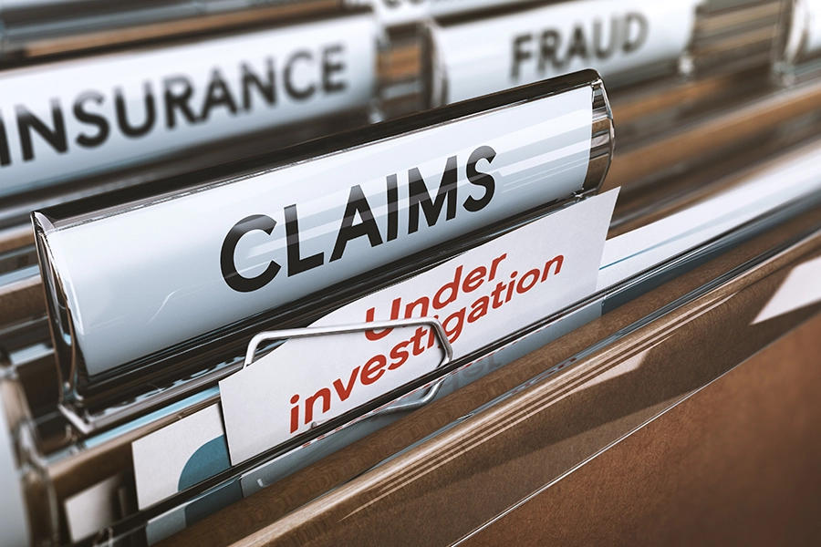 A group of files in Springfield, IL, labeled "insurance fraud, claims, and under investigation.”