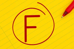 A red letter F grade on a yellow piece of paper and a red pin in Springfield, IL.