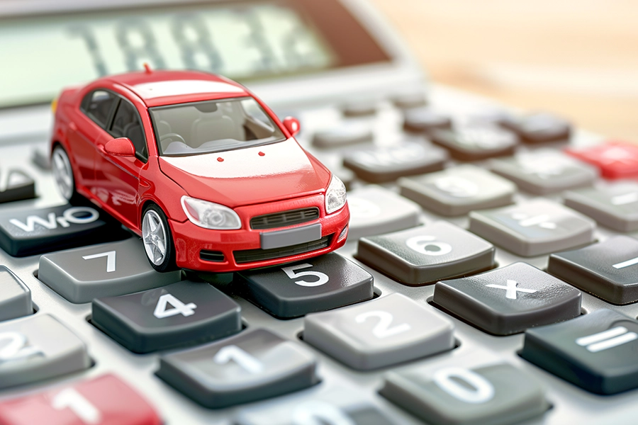 A red toy car on a calculator symbolizing a change in use tax for motor vehicles if they’re out of state from Springfield, IL.