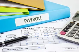 JLW Tax & Bookkeeping Services—A calculator, papers, and a binder labeled payroll on an office desk in Springfield, IL.