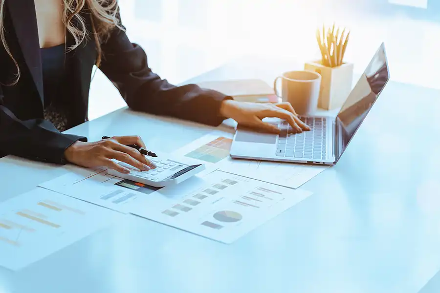 JLW Tax & Bookkeeping Services—A female accounting consultant with a laptop and calculator sitting at a desk in an office in Springfield, IL.
